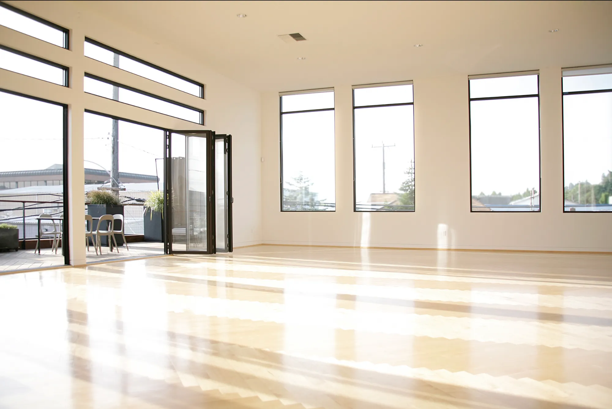 Sunlit open floor with folding doors and tall windows — daylight photo studio in Seattle