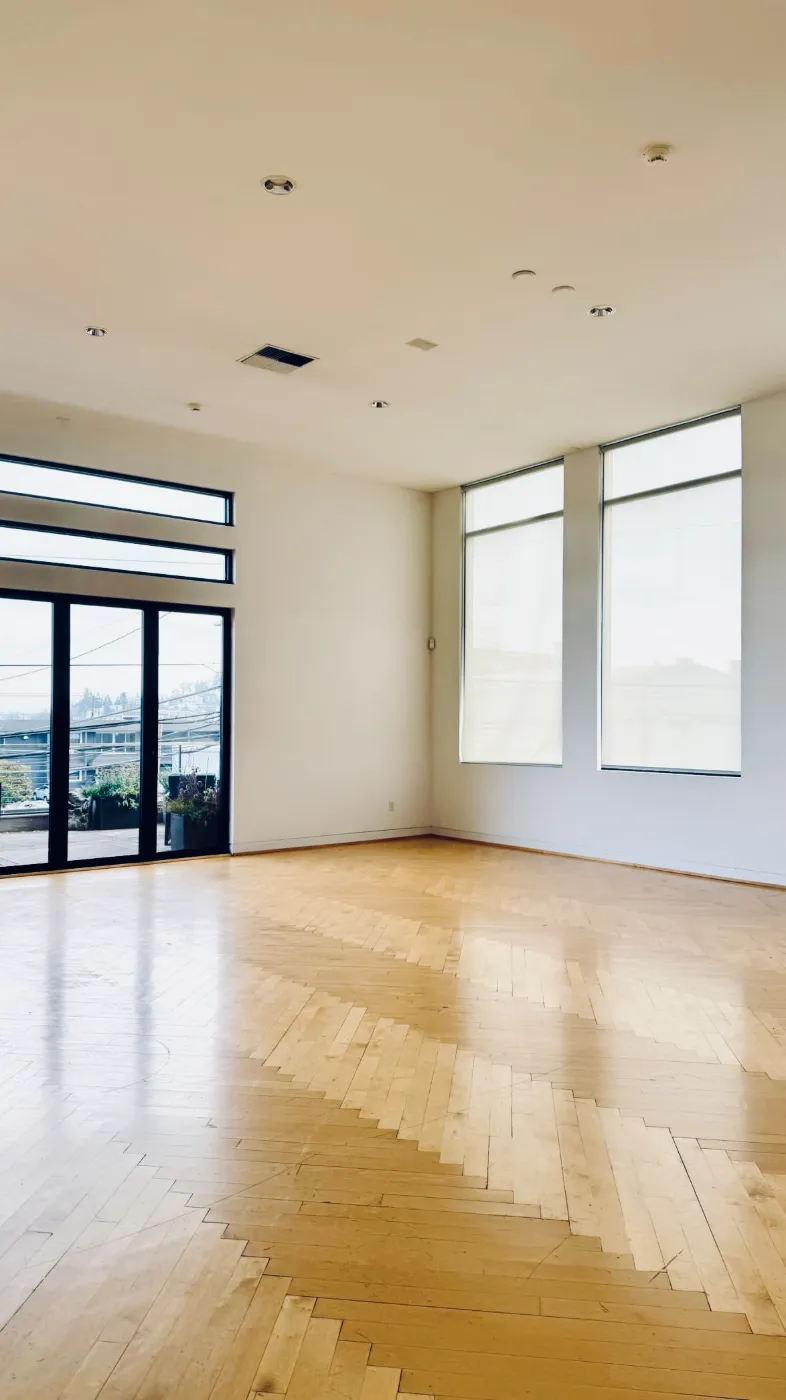 Natural light photo studio in Seattle with tall south-facing windows, glass doors and herringbone floor