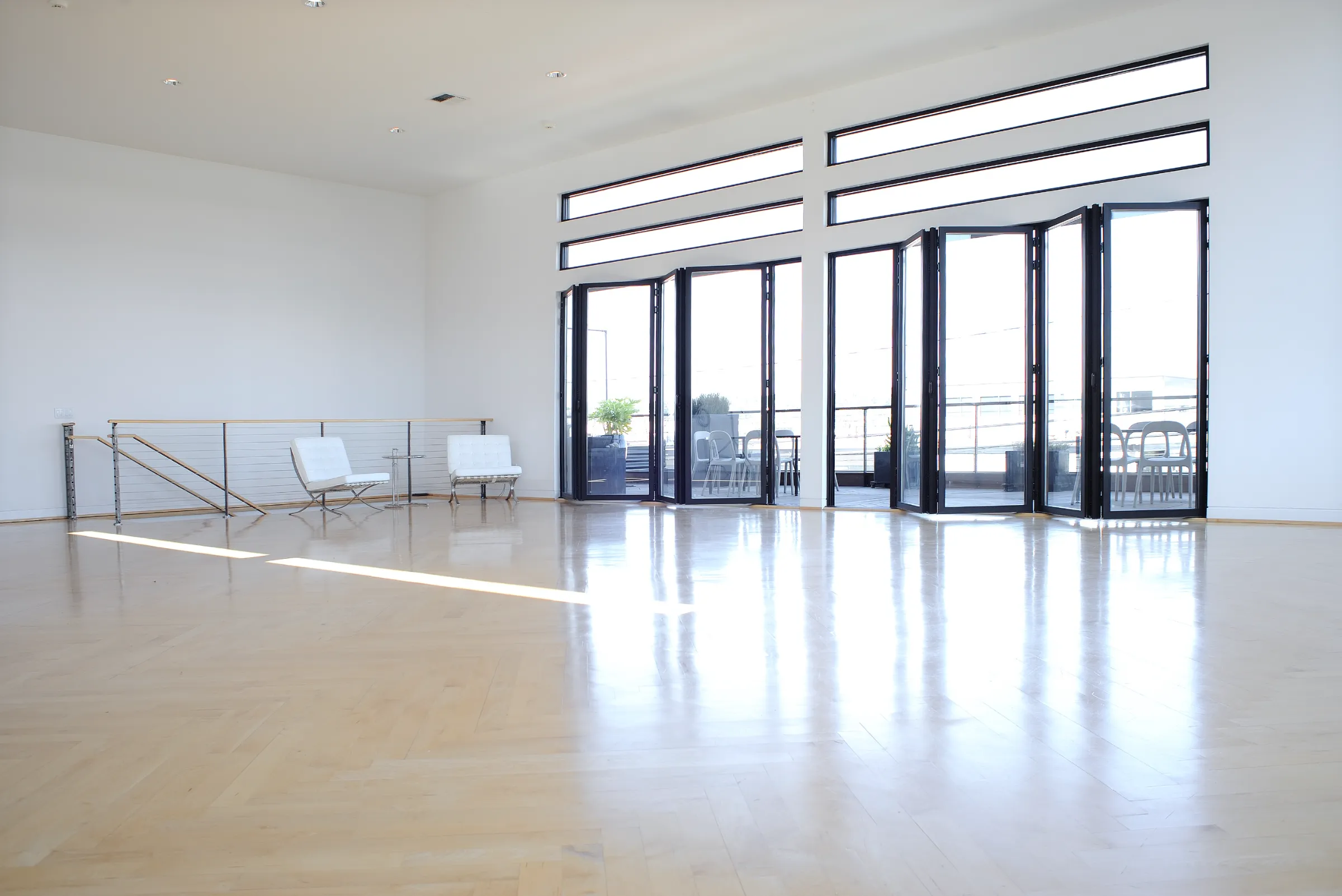 Open studio floor with folding glass doors to the deck at the Light Loft